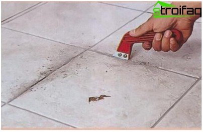 Avlägsna injekteringsbruk från golvplattor med en skrapa