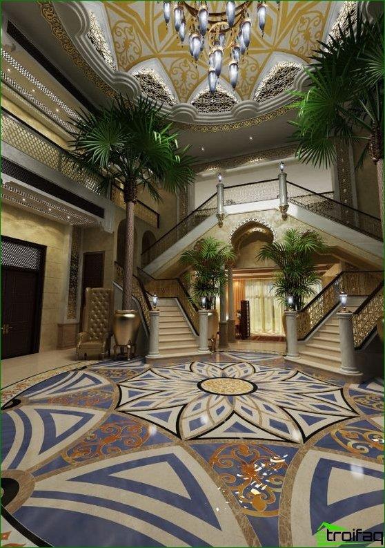 Hall i huset i stil med Maharajas: enorma palmer, ett högt kupoltak, trappor och blommotiv på tak och golv