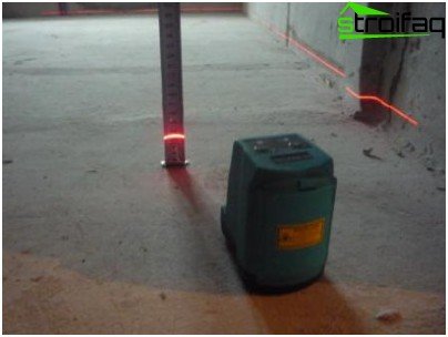 Lattiatason tarkistaminen laserilla. Kaltevuus ylittää sallitun 50 mm: n ja rakennuttajan on kohdistettava se tai korvattava ostajalle kohdistuskustannukset.