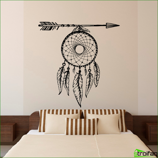 Dream catcher over the head of the bed in the bedroom in delicate cream colors.