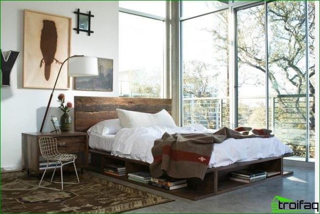 ظهر السرير على النافذة: غرفة نوم زاوية على طراز الآرت نوفو مع نوافذ بانورامية في منزل ريفي