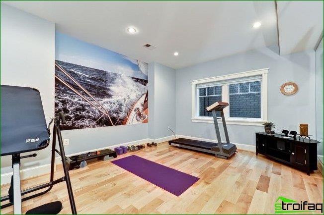 Gimnasio casero con murales en una de las paredes.